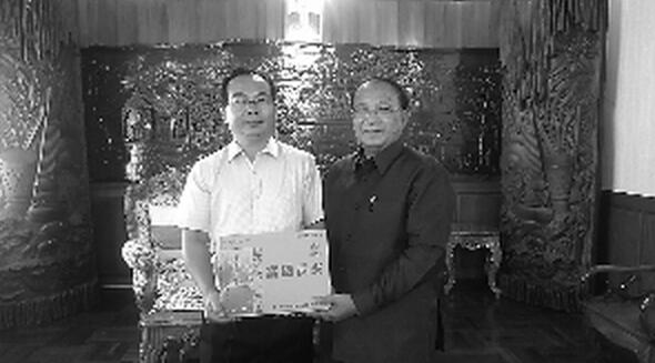 中地安公司董事长廖鹏(左一)将中国产富硒贡米亲手赠送给了老挝国家农林部部长连提乔先生(右一)